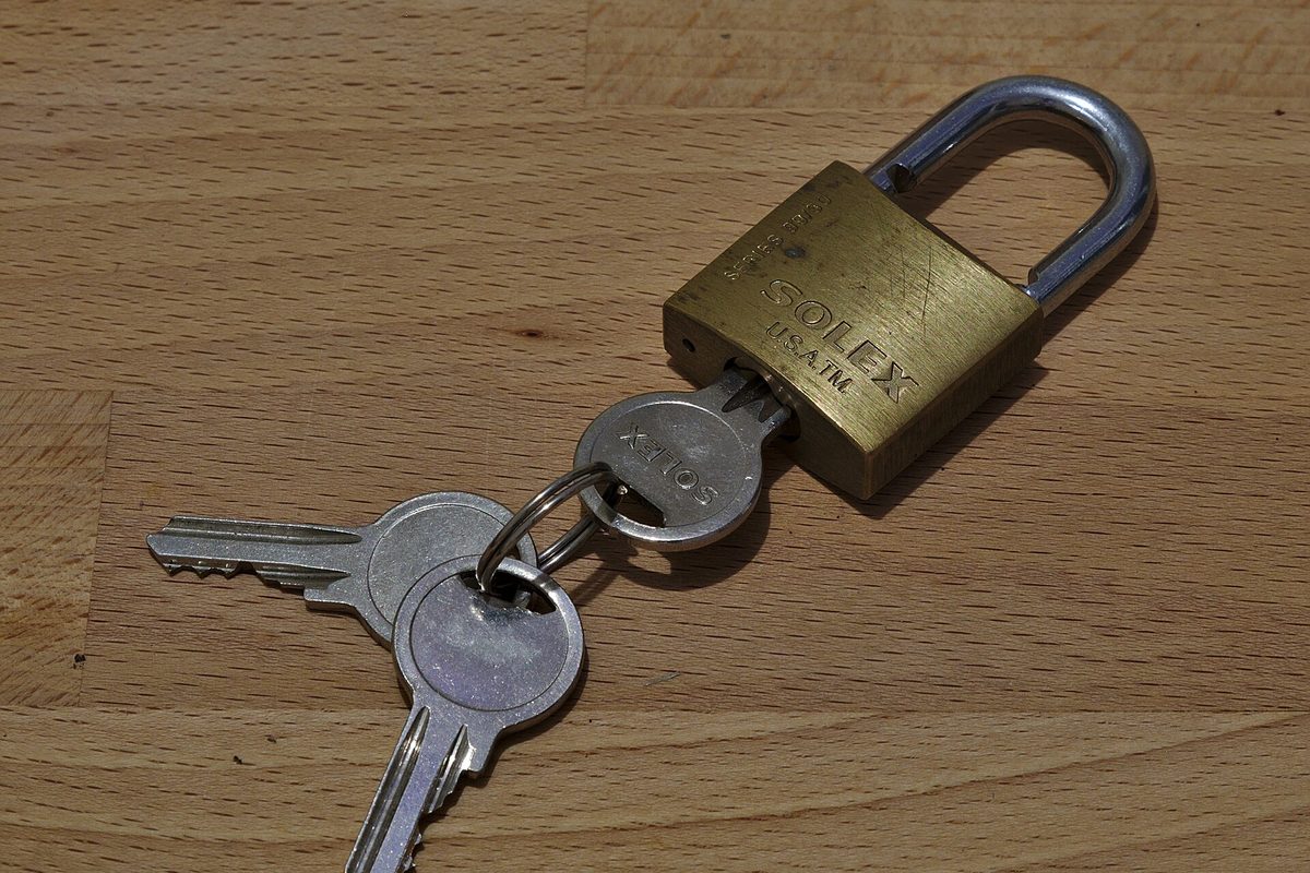 Hengelås med nøkler på et trebord – kredittsperren låser kredittopplysningene dine mens du rydder opp i anmerkningen.