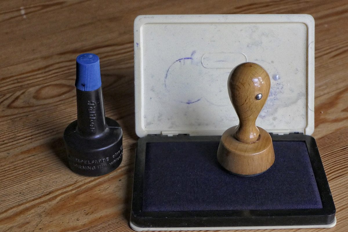 Stempel og stempelpute på et skrivebord – en betalingsanmerkning fungerer som et stempel i kredittopplysningene dine.