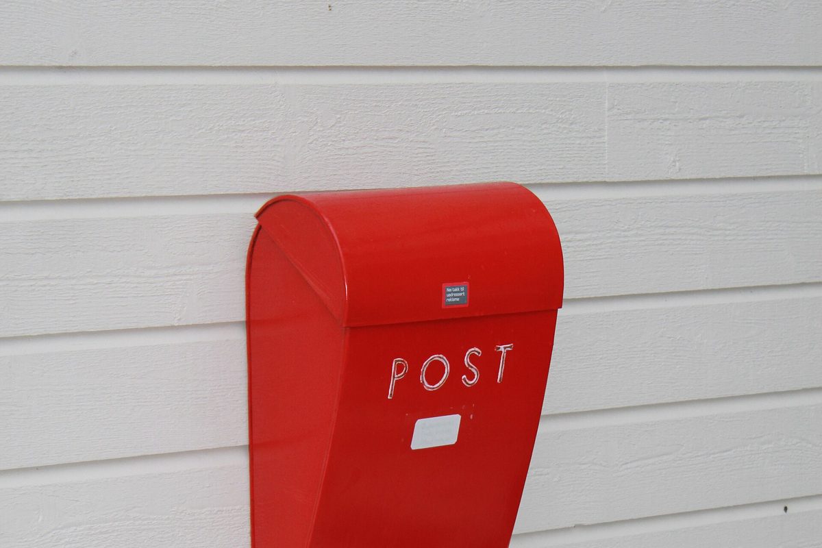 Rød norsk postkasse med klistremerket «Nei takk til uadressert reklame» – reservasjon stopper reklamen, kredittsperre stopper kredittvurderinger.