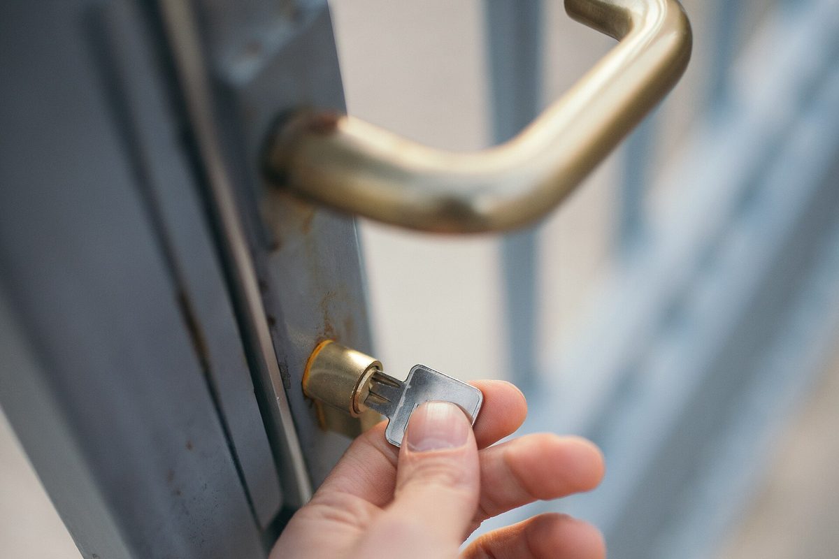Hånd som vrir nøkkelen om i en dørlås – kredittsperre er samme enkle hverdagsvane: du låser kreditten når du ikke bruker den.