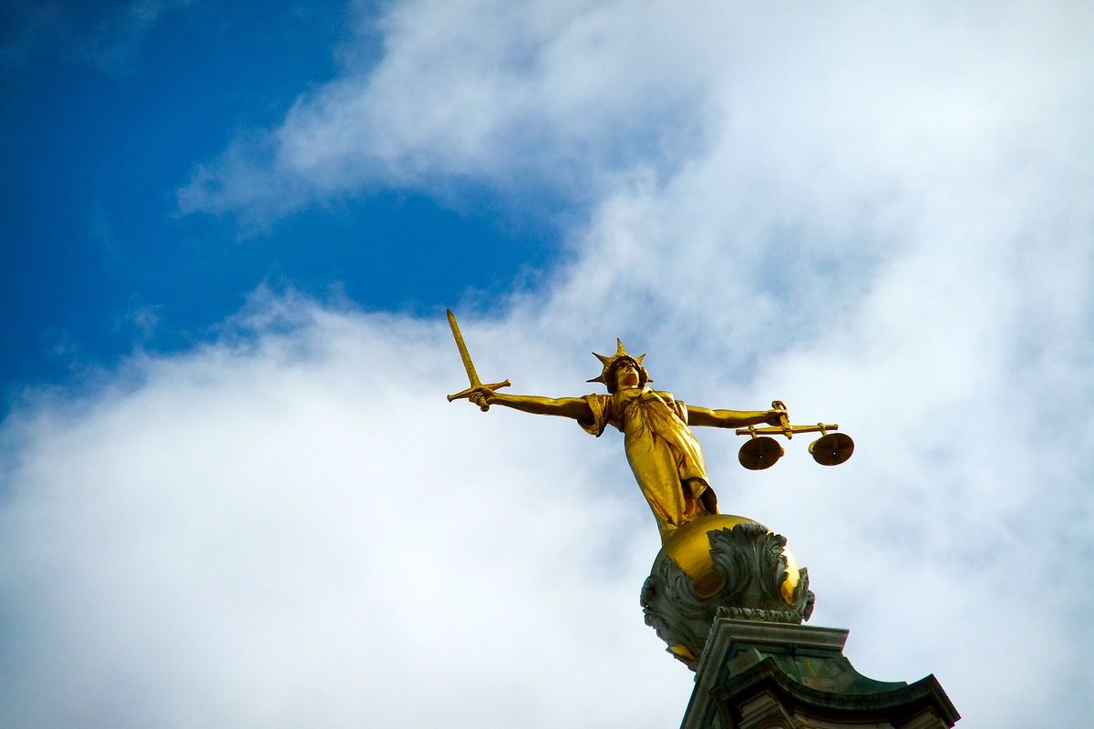 Forgylt Justitia-statue med sverd og vekt mot blå himmel – loven balanserer kredittsperrens vern mot unntakene som fortsatt gjelder.