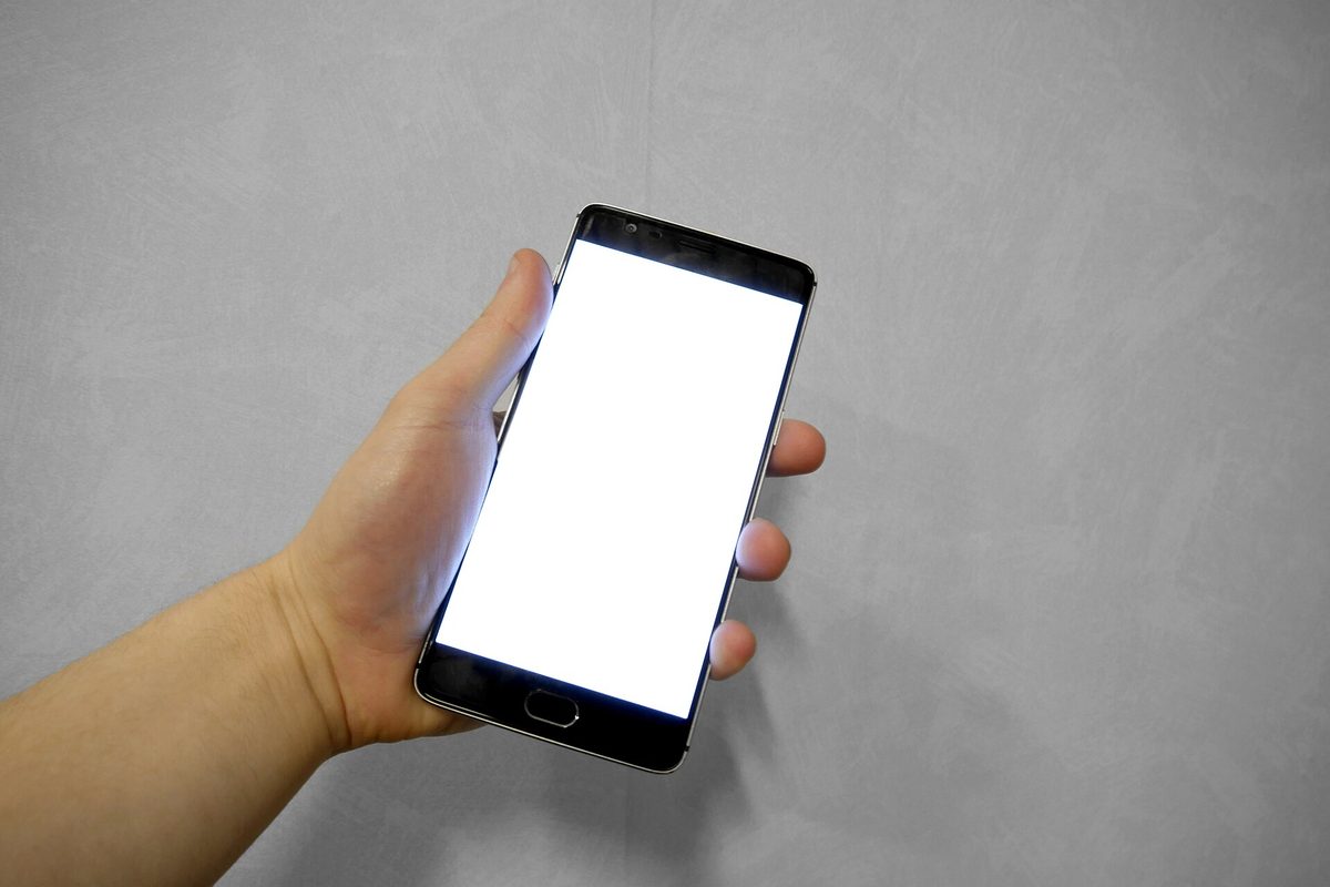 Mobiltelefon holdt i hånden – hos Bislab bekrefter du identiteten din via mobilen.
